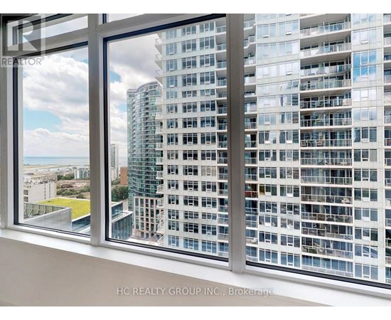 A window overlooks a cityscape with a mix of residential and commercial buildings.