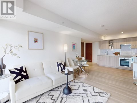 A modern living room with a white sofa and a patterned rug.