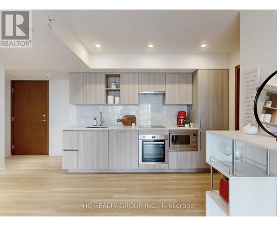 A modern kitchen with white cabinets and stainless steel appliances.