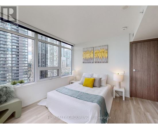 A bedroom with a large bed and a view of a city skyline.