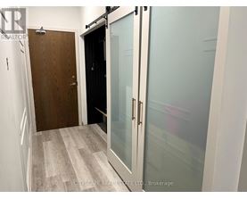 A hallway with a wooden door and a glass door.