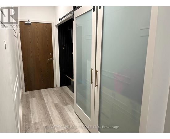A hallway with a wooden door and a glass door.