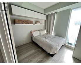A bedroom with a bed, nightstand, and window.
