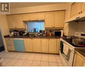 A kitchen with wooden cabinets and a white stove top oven.
