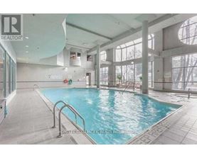 A large indoor swimming pool with a glass wall on one side.