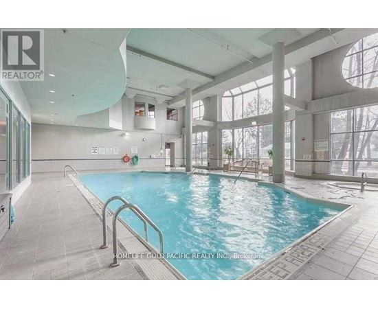 A large indoor swimming pool with a glass wall on one side.