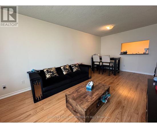A living room with a black couch and wooden coffee table.