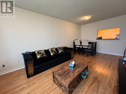 A living room with a black couch and wooden coffee table.