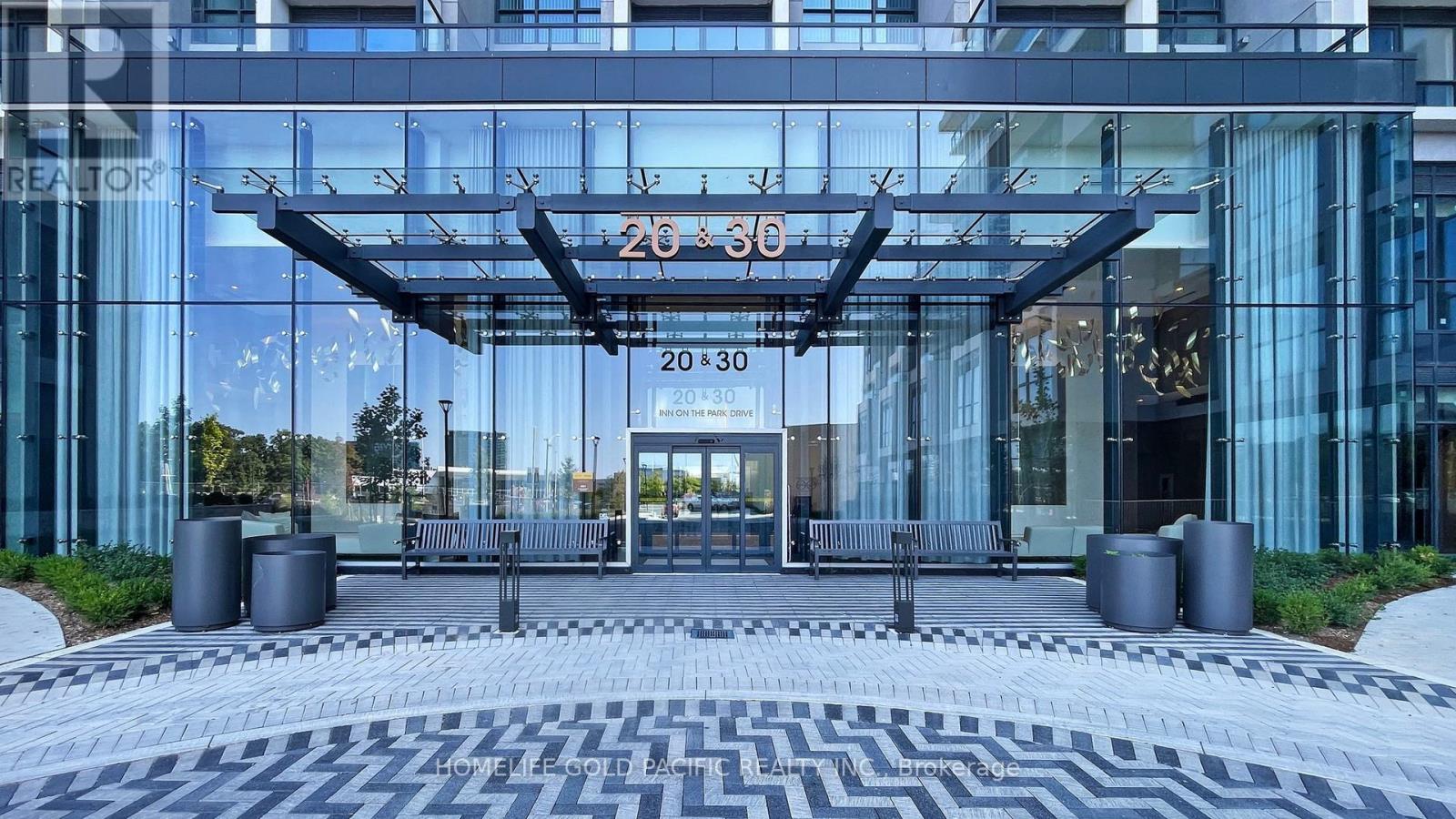 A modern building with a glass facade and a large entrance.