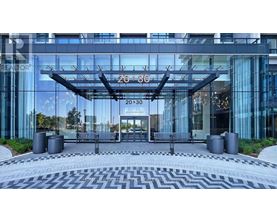 A modern building with a glass facade and a large entrance.