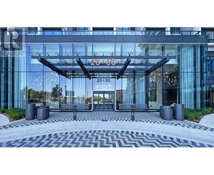 A modern building with a glass facade and a large entrance.