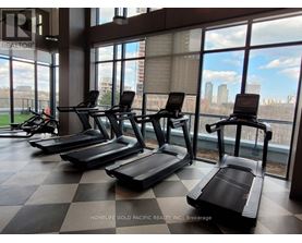 A gym with treadmills and a view of the city.