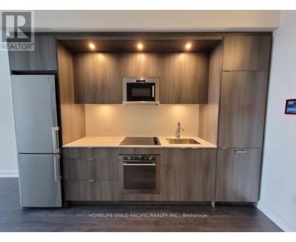 A modern kitchen with wooden cabinets and stainless steel appliances.