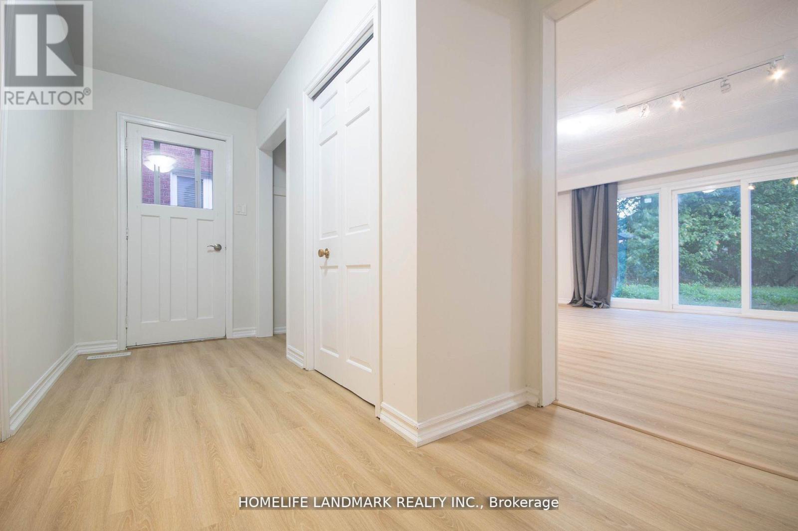 A room with a door and a window with a view of trees.