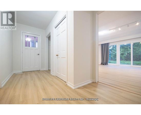 A room with a door and a window with a view of trees.