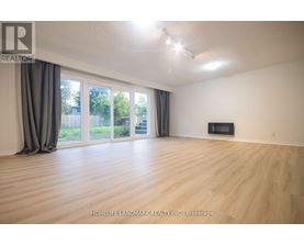 A spacious room with wooden flooring and a television in the corner.