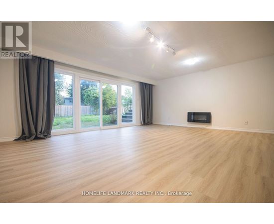A spacious room with wooden flooring and a television in the corner.
