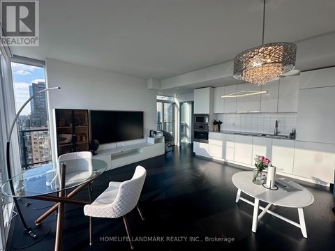 A modern living room with a glass table and white chairs.