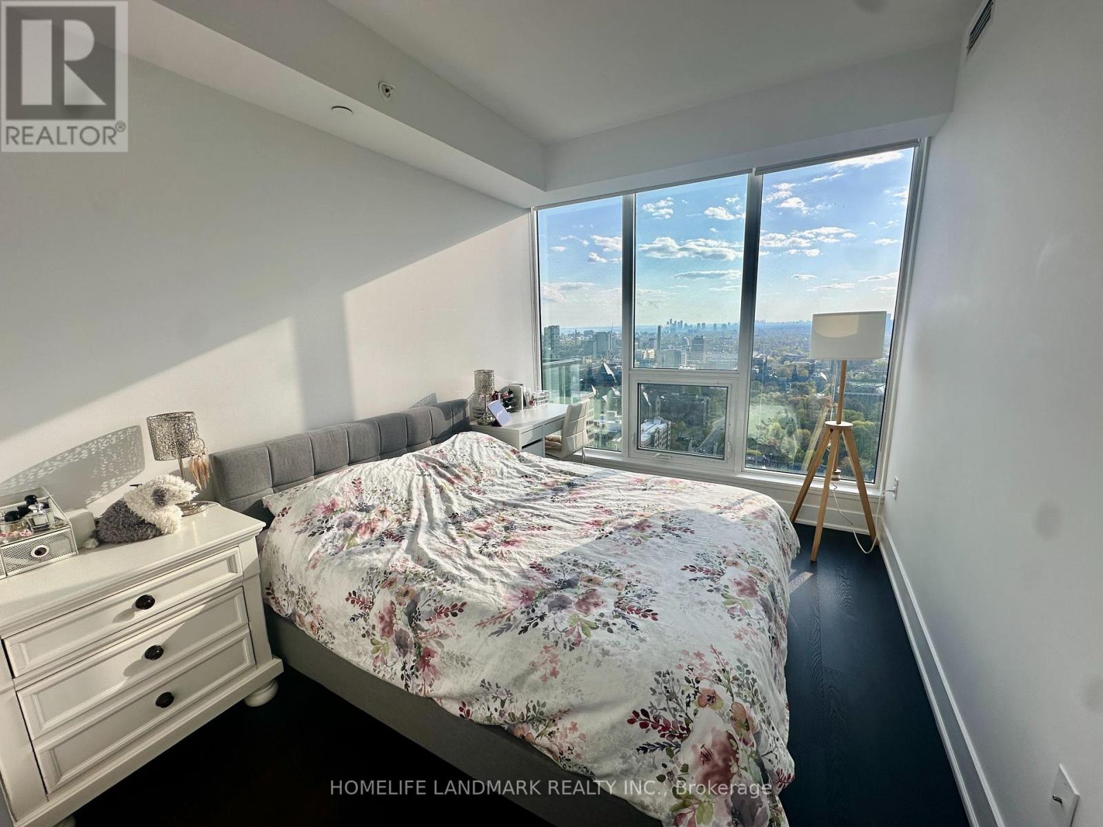 A bedroom with a large bed and a view of the city.