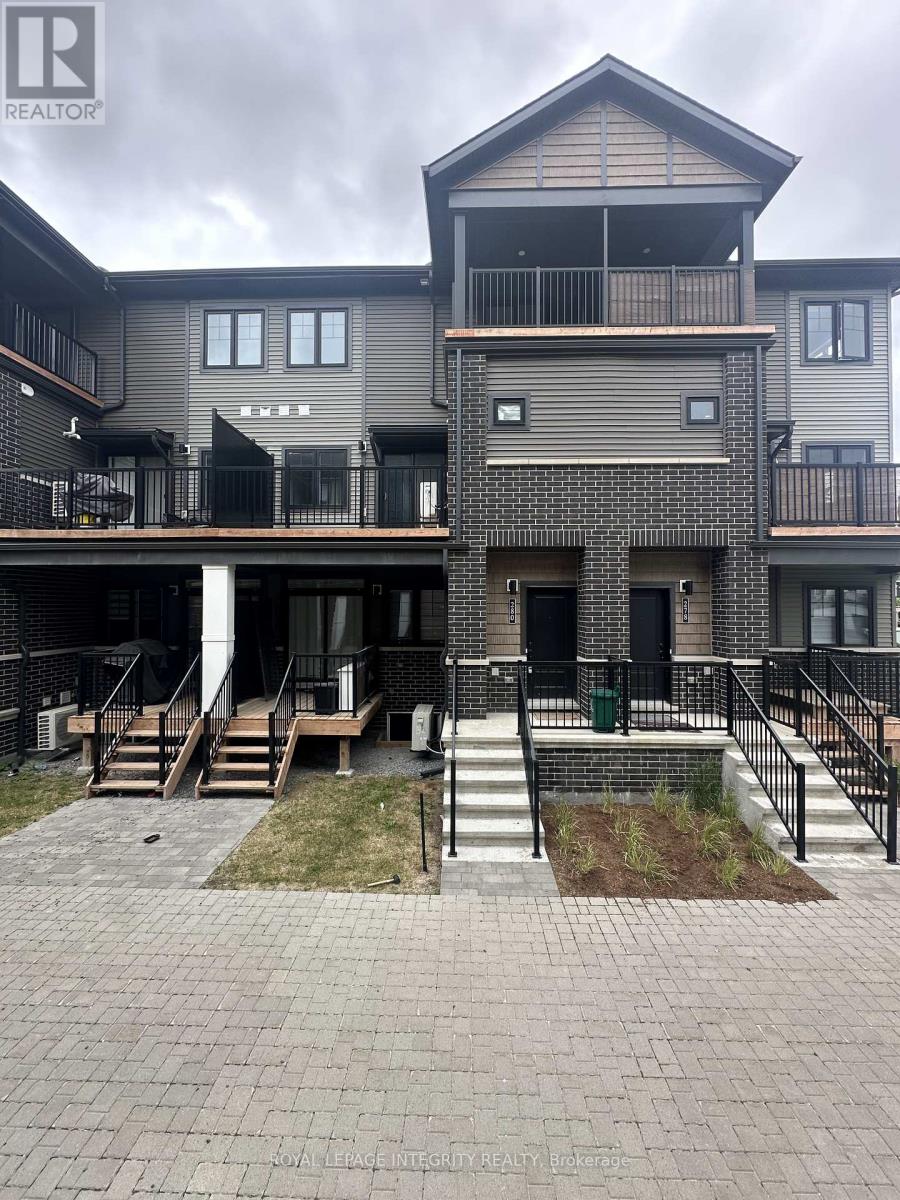 A real estate photo of a multi-story building with a balcony and stairs leading to the entrance.