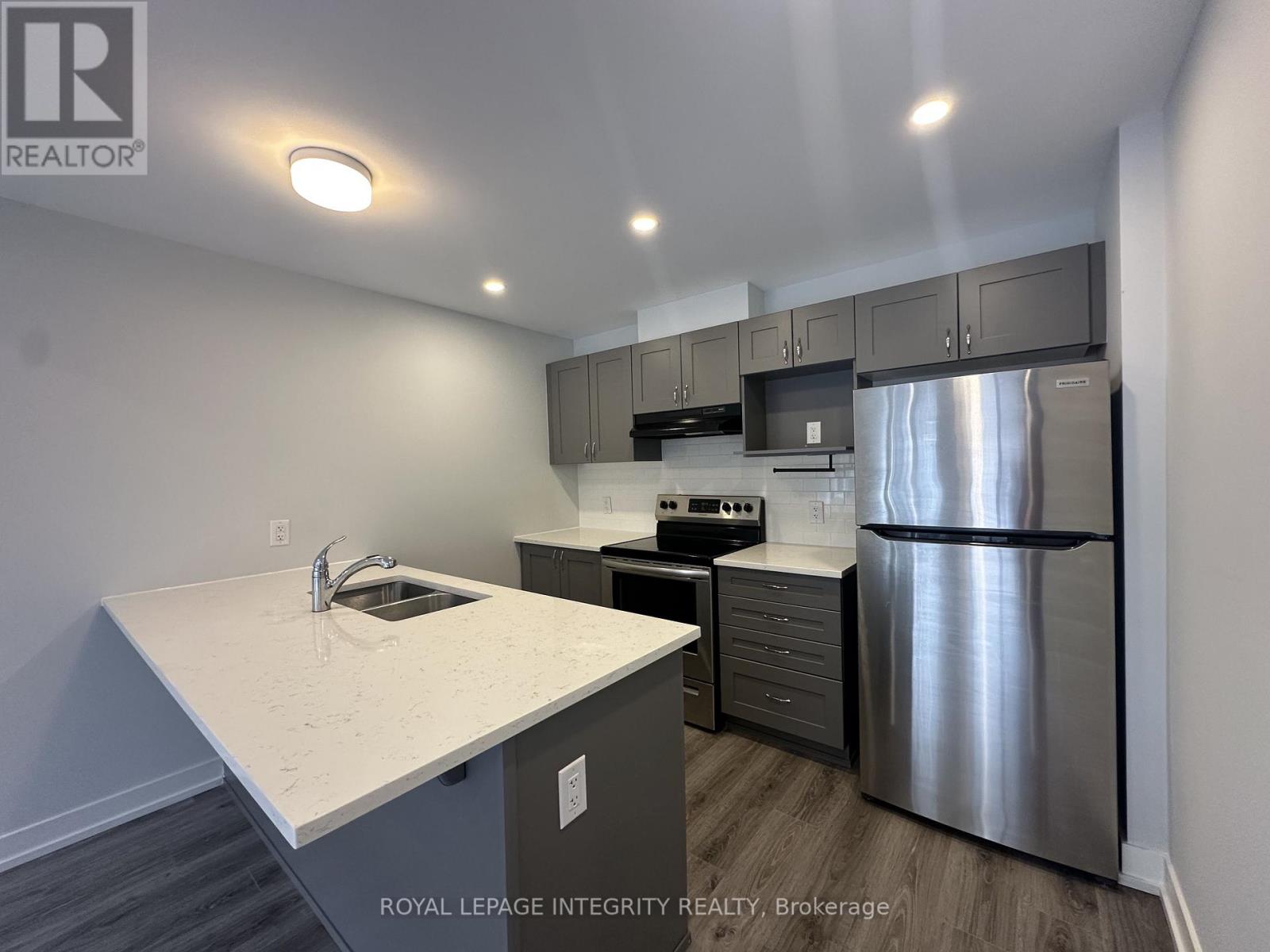 A kitchen with a stainless steel refrigerator and a white countertop.