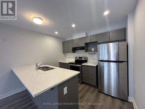 A kitchen with a stainless steel refrigerator and a white countertop.