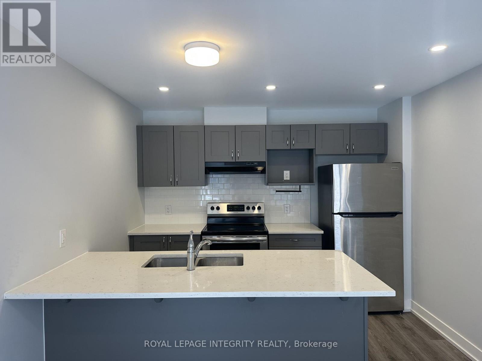A kitchen with a white countertop and stainless steel appliances.