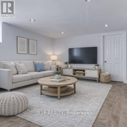 A well-lit living room with a white sofa, a wooden coffee table, and a flat-screen TV mounted on the wall.