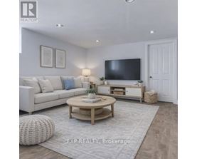 A well-lit living room with a white sofa, a wooden coffee table, and a flat-screen TV mounted on the wall.