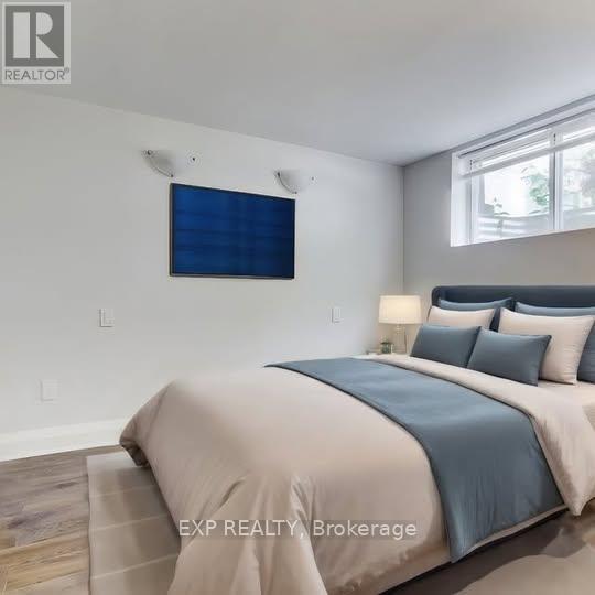 A bedroom with a bed, pillows, and a window.