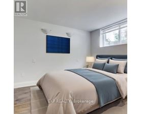 A bedroom with a bed, pillows, and a window.