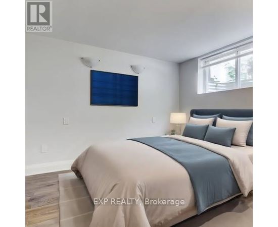 A bedroom with a bed, pillows, and a window.