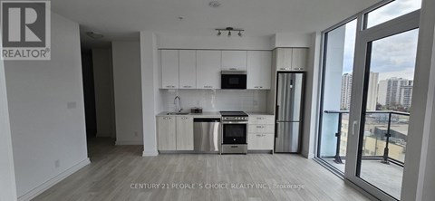 A modern kitchen with white cabinets and stainless steel appliances.