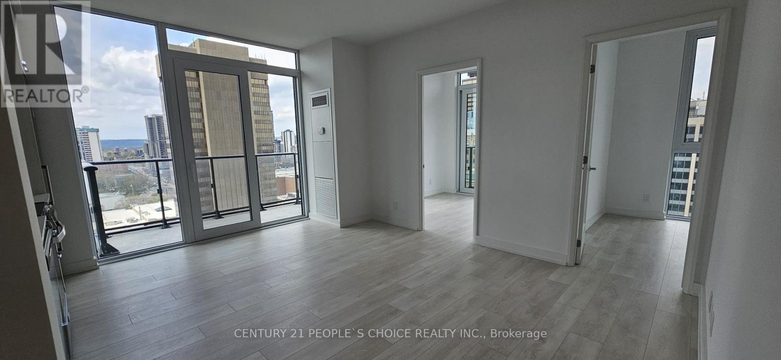 A spacious room with a view of the cityscape through large windows.