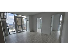 A spacious room with a view of the cityscape through large windows.
