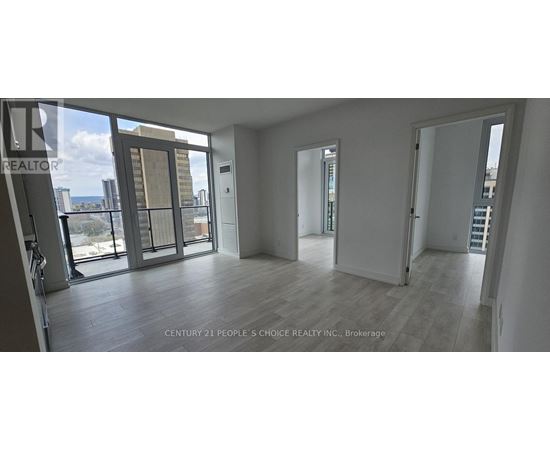 A spacious room with a view of the cityscape through large windows.