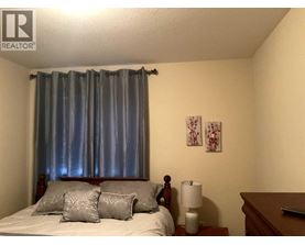 A bedroom with a bed, nightstand, and lamp.