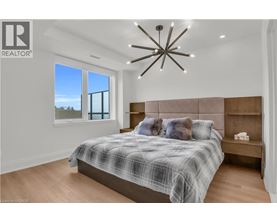 A bedroom with a bed, a bench, and a window overlooking the ocean.