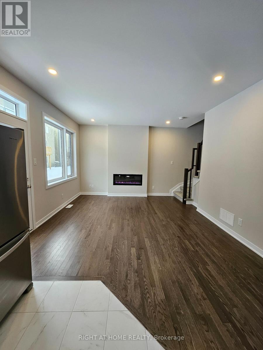 A spacious room with wood flooring and a fireplace.