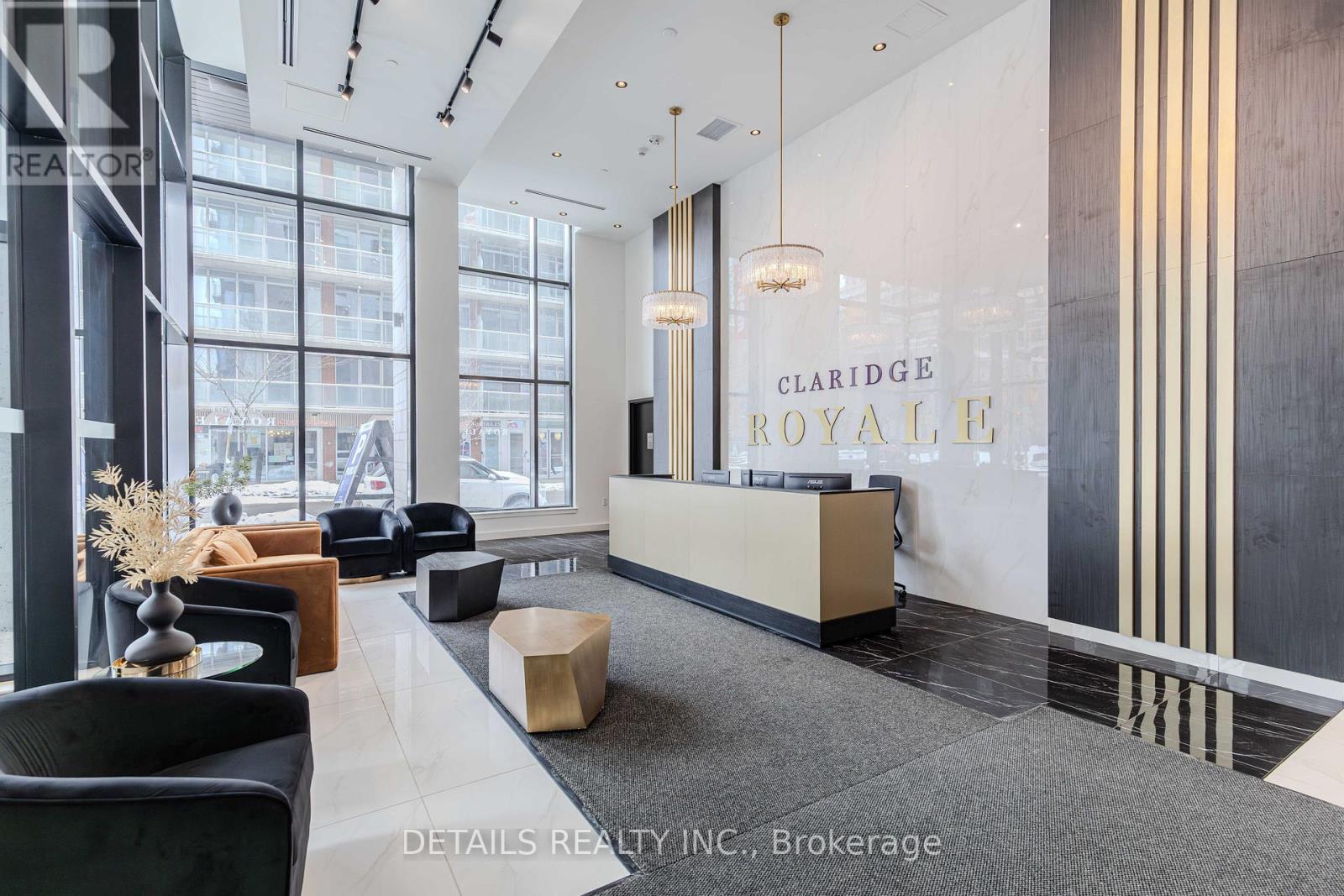 A reception area with a desk and chairs in front of a Claridge Royale sign.