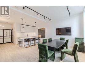 A modern dining room with a black table and green chairs.