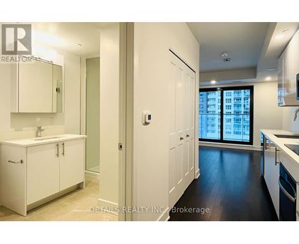 A modern kitchen with white cabinets and a large window.