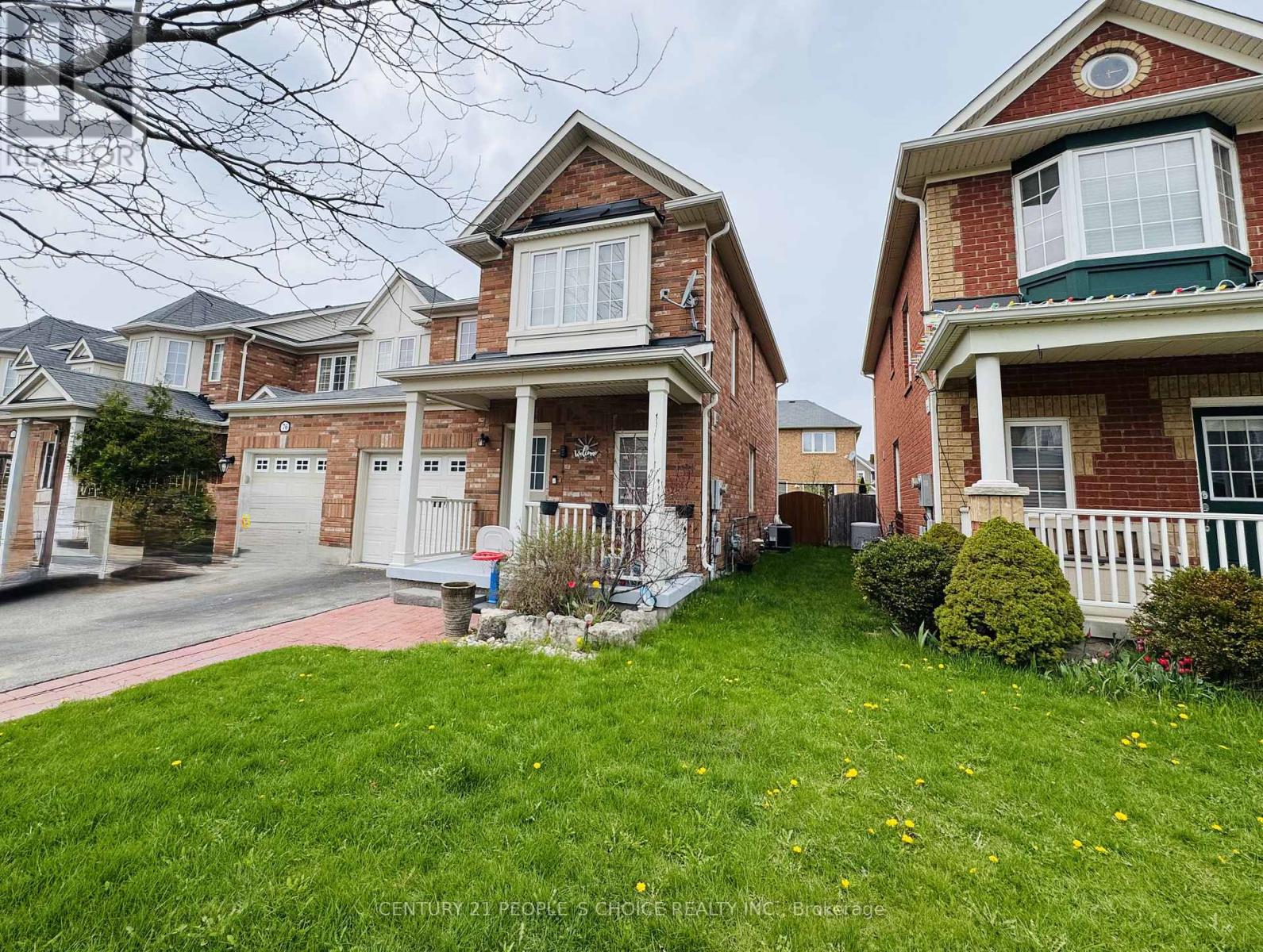 A row of houses with green lawns in front.