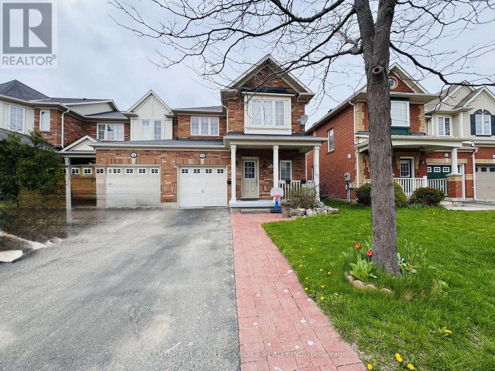 A large brick house with a driveway in front.