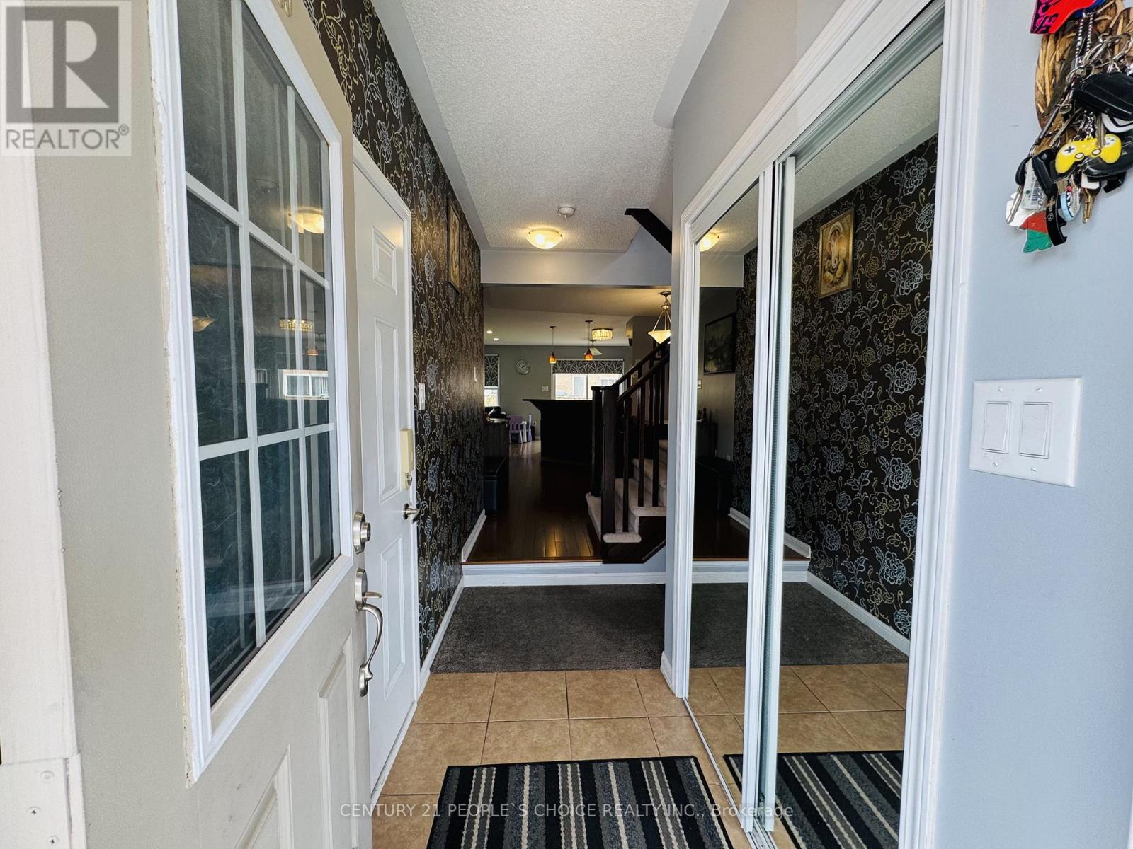 A hallway with a rug on the floor and a door on the left.