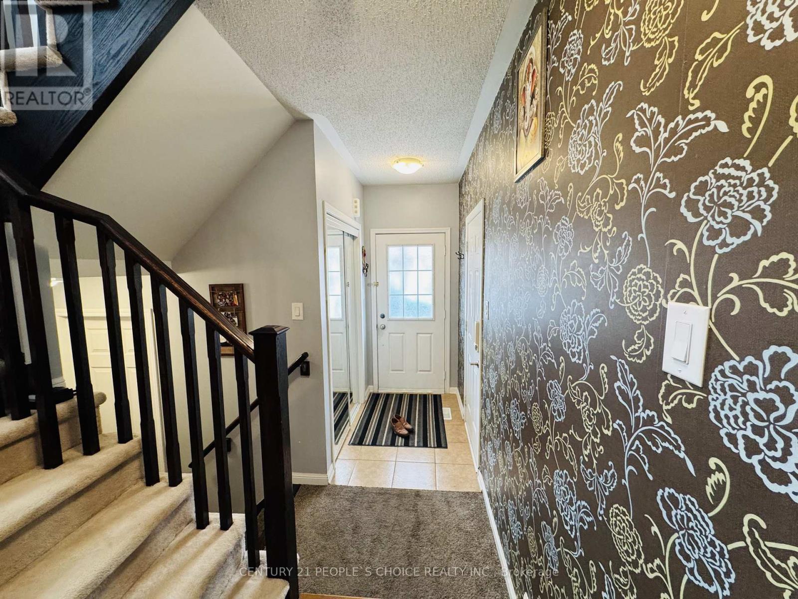 A hallway with a staircase and a door.