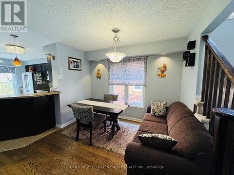A living room with a brown couch and a dining table.