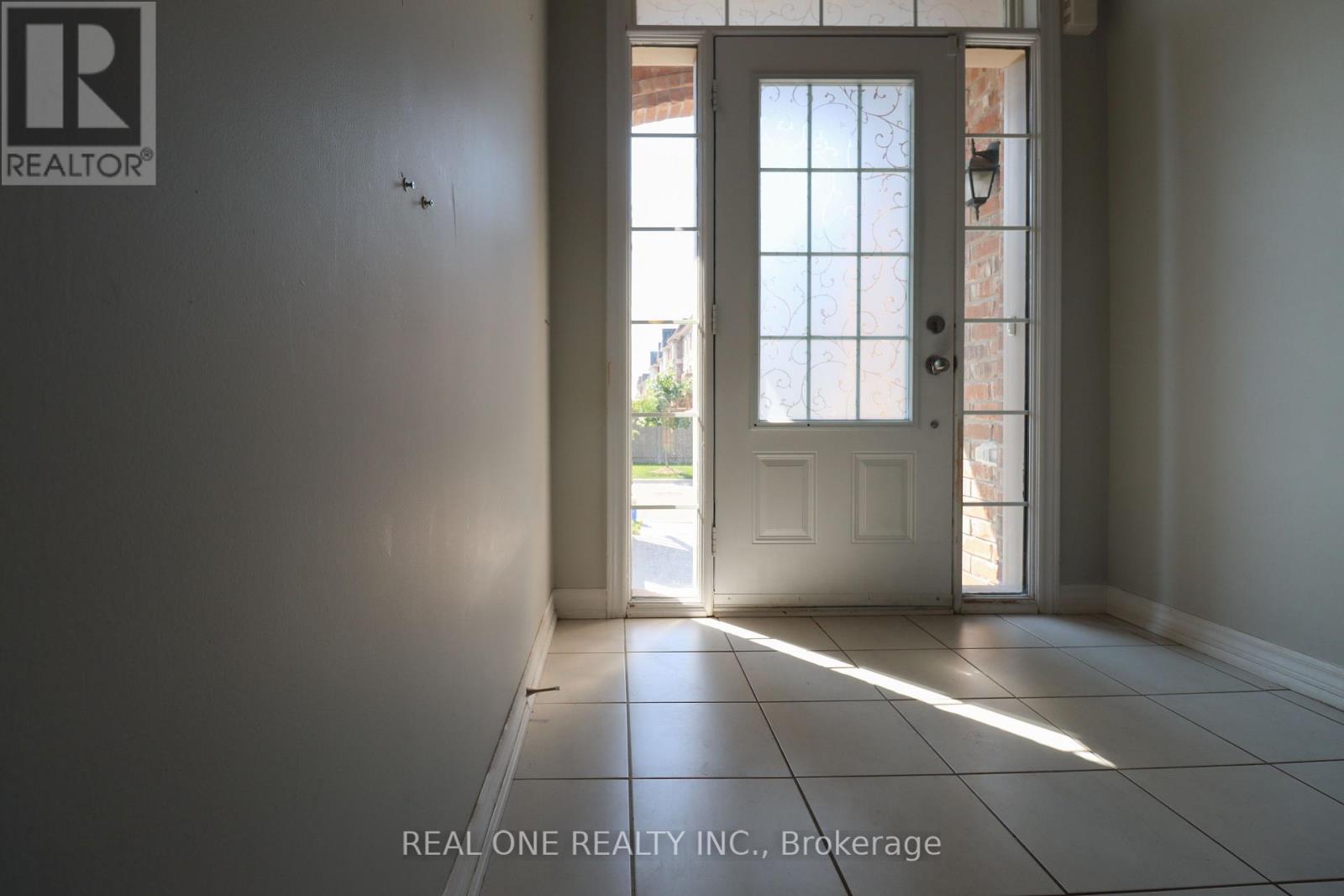 A white door with a glass window is in a room with a tiled floor.