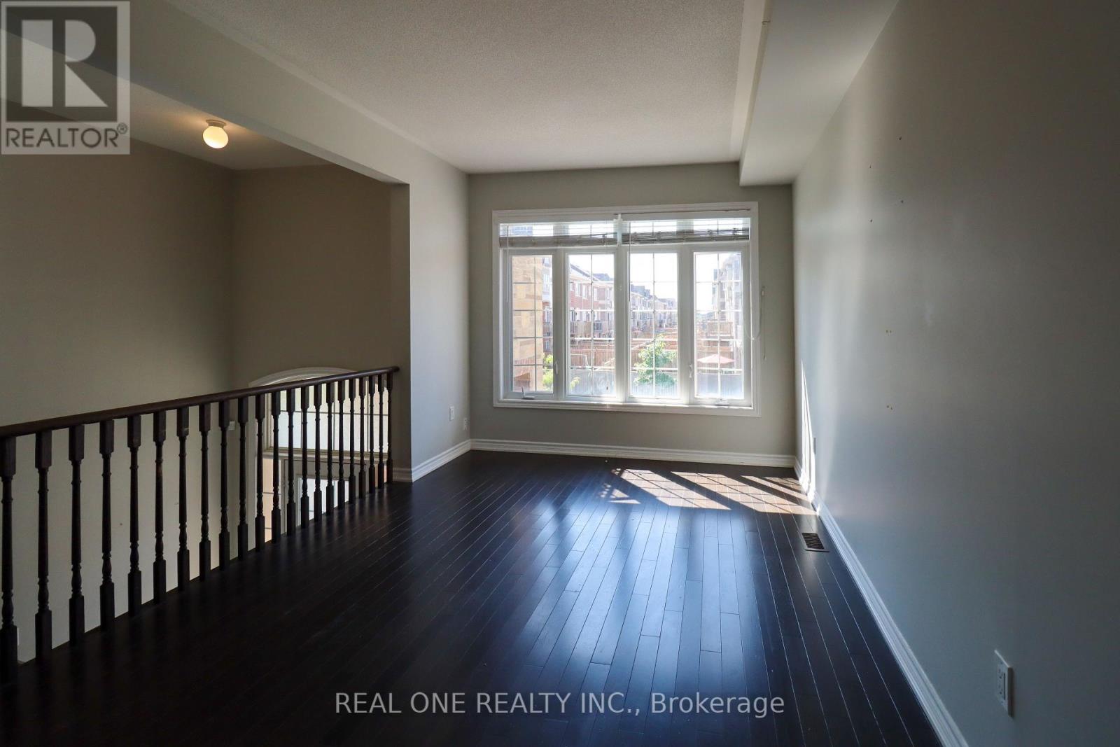 A room with a window and a wooden floor.