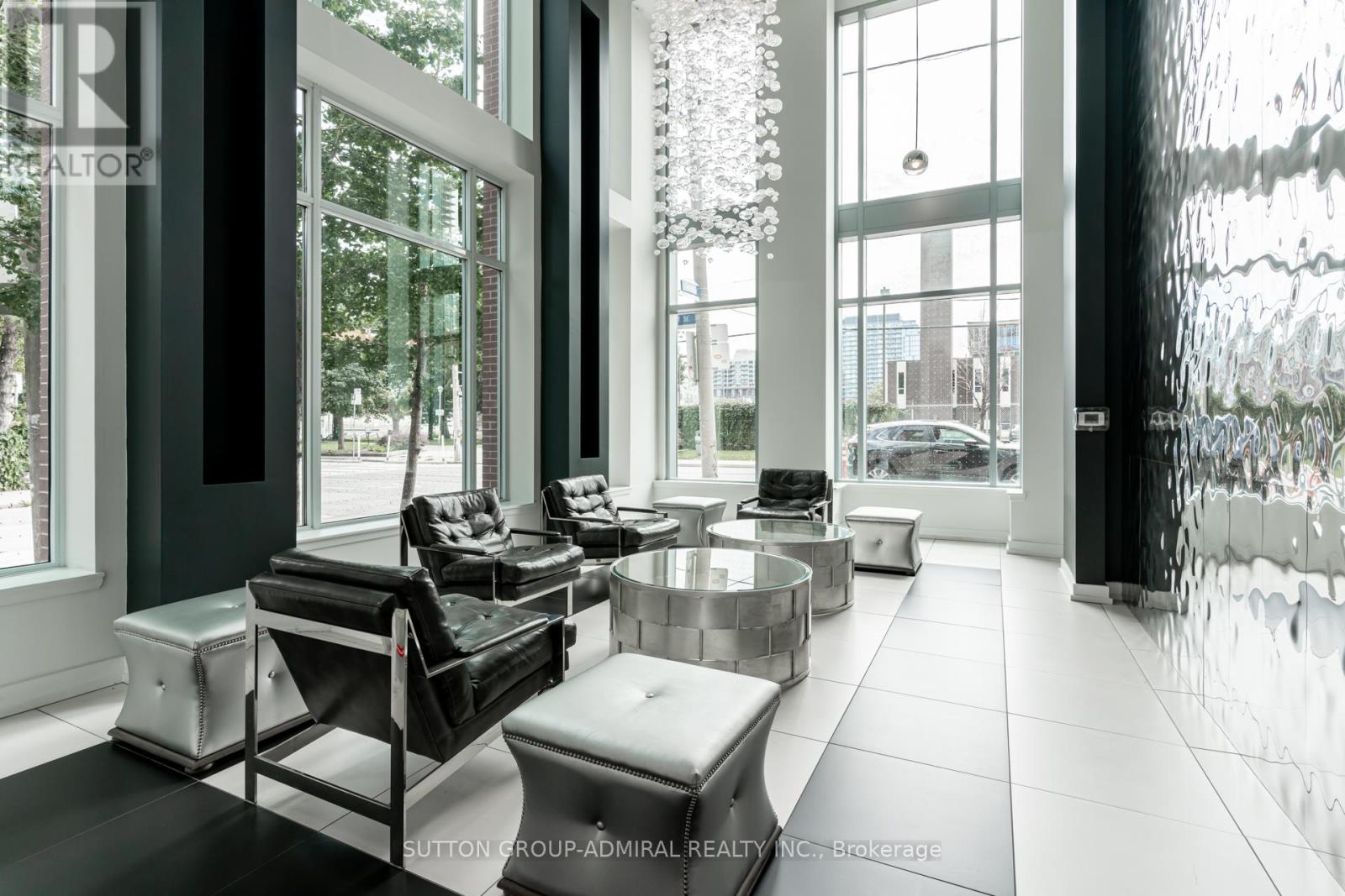A modern living room with black and white furniture and large windows.